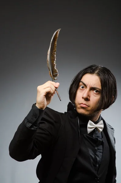 Young man with writing feather — Stock Photo, Image