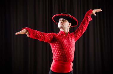 Kırmızı elbiseli bir adam İspanyol dansı yapıyor.