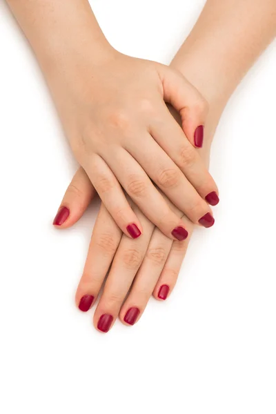 Mani donna con chiodo rosso isolato su bianco — Foto Stock