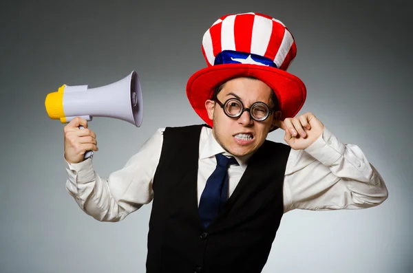 Man with loudspeaker wearing american hat — Stock Photo, Image