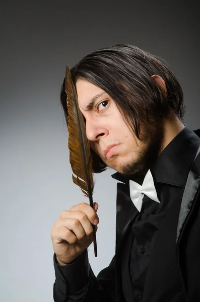 Young man with writing feather — Stock Photo, Image