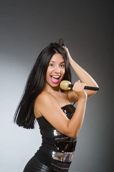 Young woman singing in karaoke club — Stock Photo, Image