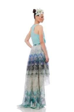 Beyaz üzerinde mavi çiçekli elbise giyen beyaz bir model.