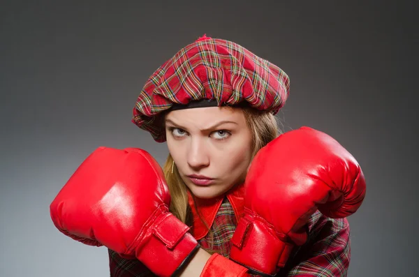 Vrouw in Schotse kleding in boksconcept — Stockfoto