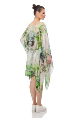 Beyaz üzerinde uzun ve zarif bir elbise giyen güzel bir manken.