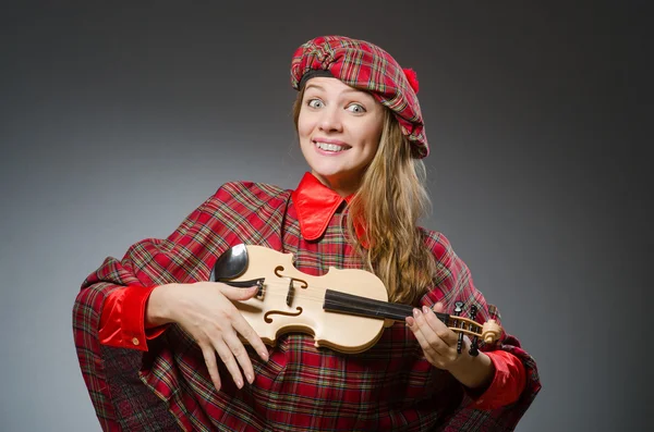 Женщина в шотландской одежде в музыкальной концепции — стоковое фото
