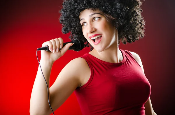 Kobieta z fryzura afro śpiewu w karaoke — Zdjęcie stockowe