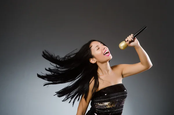 Mladá žena zpívá v karaoke klubu — Stock fotografie