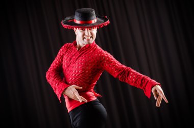 Kırmızı elbiseli bir adam İspanyol dansı yapıyor.