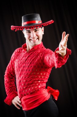 Kırmızı elbiseli bir adam İspanyol dansı yapıyor.