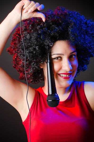 Mujer con peinado afro cantando en karaoke —  Fotos de Stock