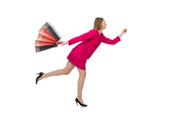 Shopper girl in pink dress holding plastic bags isolated on white — Stock Photo, Image