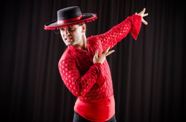 Kırmızı elbiseli bir adam İspanyol dansı yapıyor.