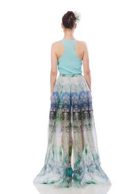 Beyaz üzerinde mavi çiçekli elbise giyen beyaz bir model.