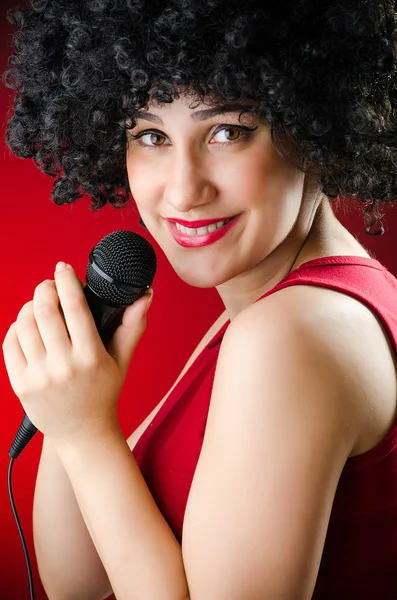 Donna con acconciatura afro che canta nel karaoke — Foto Stock