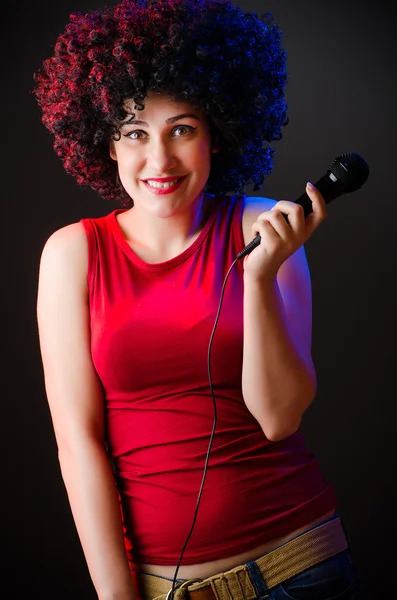 Mulher com penteado afro cantando em karaoke — Fotografia de Stock