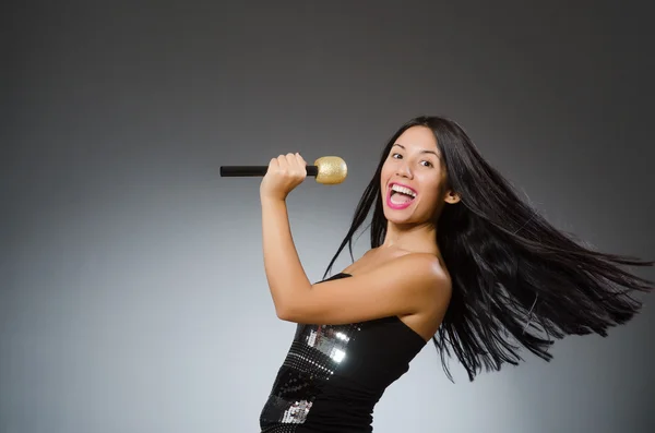 Jovem mulher cantando no clube de karaoke — Fotografia de Stock