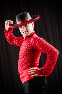 Kırmızı elbiseli bir adam İspanyol dansı yapıyor.