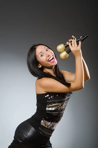 Mladá žena zpívá v karaoke klubu — Stock fotografie