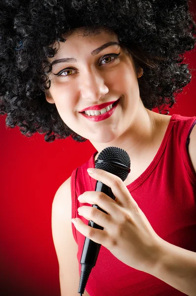 Frau mit Afro-Frisur singt im Karaoke — Stockfoto