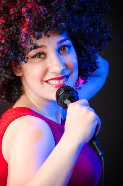 Mujer con peinado afro cantando en karaoke —  Fotos de Stock