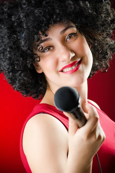 Mulher com penteado afro cantando em karaoke — Fotografia de Stock