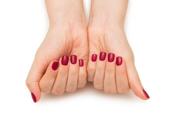 Mani donna con chiodo rosso isolato su bianco — Foto Stock