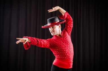 Kırmızı elbiseli bir adam İspanyol dansı yapıyor.