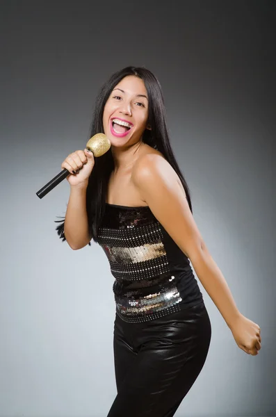 Young woman singing in karaoke club — Stock Photo, Image