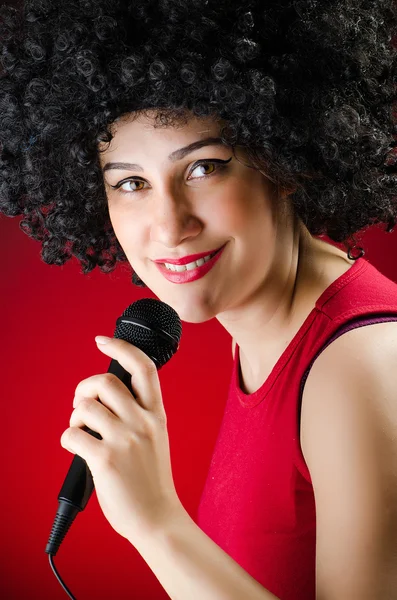Žena s afro účes zpěv karaoke — Stock fotografie