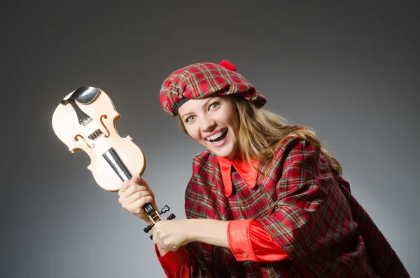 Vrouw in Schotse kleding in muzikaal concept — Stockfoto