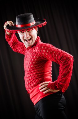 Kırmızı elbiseli bir adam İspanyol dansı yapıyor.