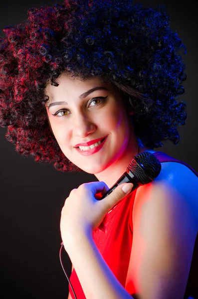Mujer con peinado afro cantando en karaoke —  Fotos de Stock