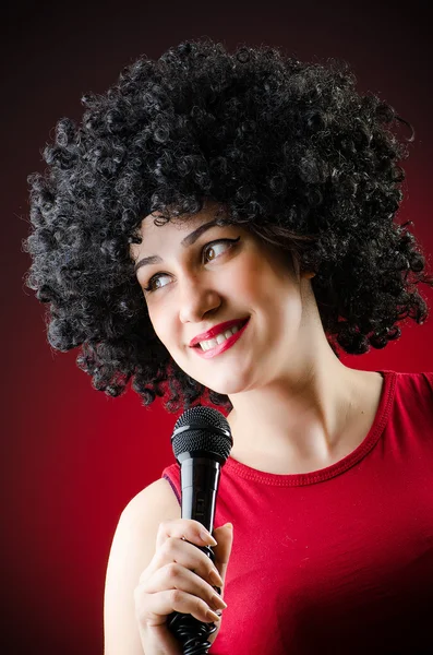 Vrouw met afro kapsel zingen Karaoke — Stockfoto