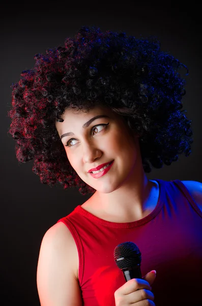 Mulher com penteado afro cantando em karaoke — Fotografia de Stock