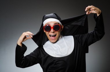 Komik bir şekilde rahibe kıyafeti giyen bir adam.