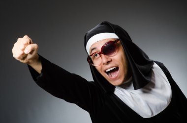 Komik bir şekilde rahibe kıyafeti giyen bir adam.