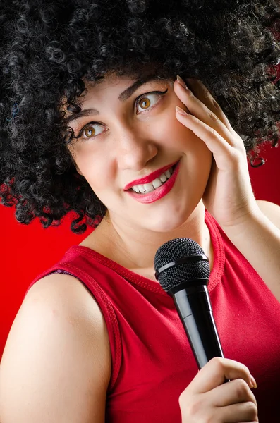 Mulher com penteado afro cantando em karaoke — Fotografia de Stock