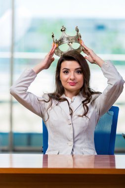 İş kadını büro masasında oturuyor.