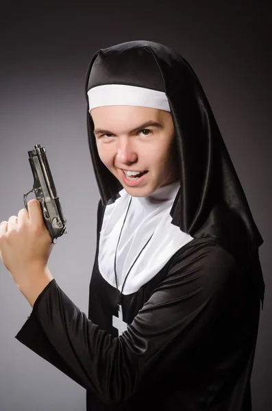 Мужчина, одетый как монашка с пистолетом — стоковое фото