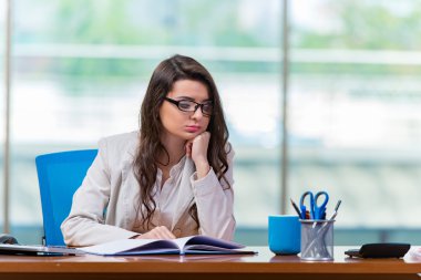 İş kadını büro masasında oturuyor.