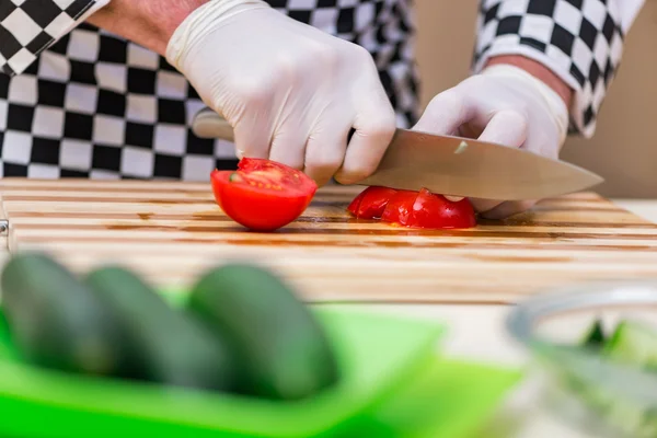 Мужской повар готовит еду на кухне — стоковое фото