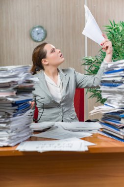 Woman under stress from excessive paper work clipart