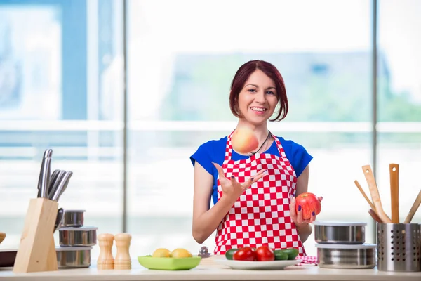 Jonge vrouw werkt in de keuken — Stockfoto
