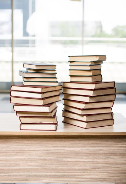 Pilha de livros arranjou a mesa de escritório — Fotografia de Stock