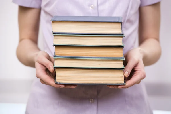 Jovem estudante com pilha de livros — Fotografia de Stock