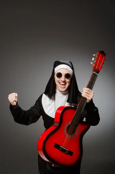 Nonne drôle avec jeu de guitare rouge — Photo