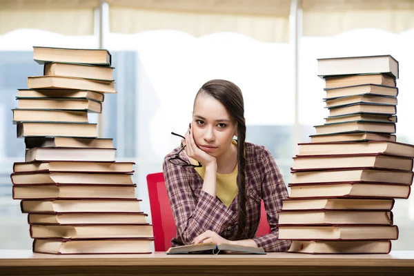 Jovem estudante com pilha de livros — Fotografia de Stock