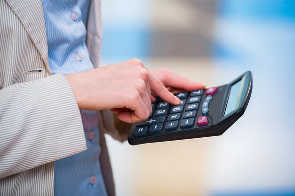 Manos calculando el beneficio en la calculadora —  Fotos de Stock