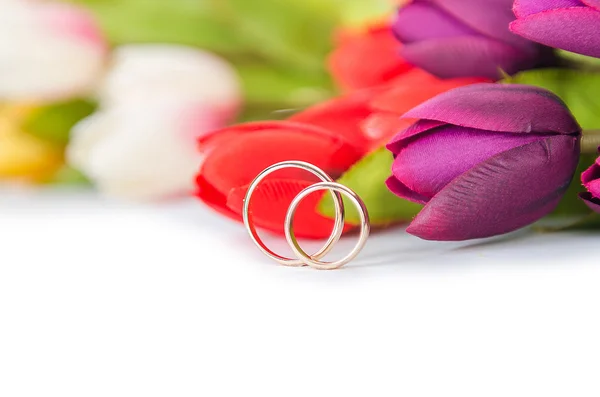 Anéis de casamento e flores isoladas no fundo branco — Fotografia de Stock